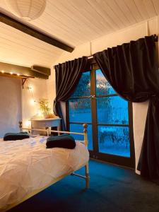 1 dormitorio con cama y ventana grande en Outhouse Bothy, en Kirkby Lonsdale