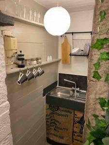 una cocina con fregadero y una caja al lado en Outhouse Bothy, en Kirkby Lonsdale