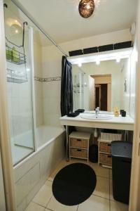 een badkamer met een bad, een wastafel en een douche bij **La Kreolita** near Paris / Disneyland Paris in Meaux