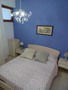 a bedroom with a bed with a blue wall at Casa Vacanze Lifra in Santa Maria di Castellabate +17 photos