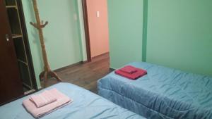 ウシュアイアにあるPolo Australの部屋にはタオルが敷かれたベッドが2つある