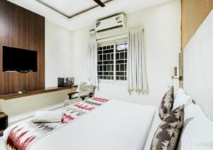 a white bedroom with a bed and a window at Euphoria Extended Stays - OMR IT Expressway Chennai in Chennai
