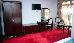 Habitación con escritorio, silla y mesa. en Ras Amba Hotel en Addis Abeba