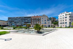 a courtyard in a city with buildings and a fountain at Paparazzi Apartment in Split