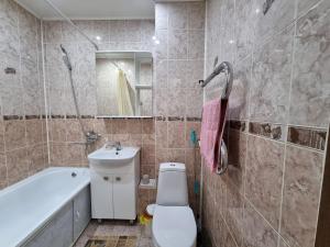 uma casa de banho com um WC, um lavatório e uma banheira em Посуточная квартира на Курмангазы c Wi-Fi em Oral