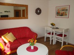sala de estar con sofá rojo y mesa en Ferienwohnung in zentraler ruhiger Lage Klatt in Kappeln, en Kappeln