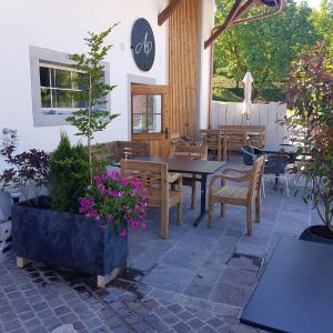 eine Terrasse mit einem Tisch, Stühlen und Blumen in der Unterkunft Auberge Passepartout in Zeihen
