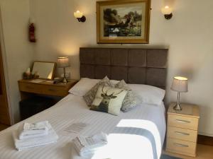 a bed with a picture of a deer on the pillows at Whortleberry Studio B & B in Porlock