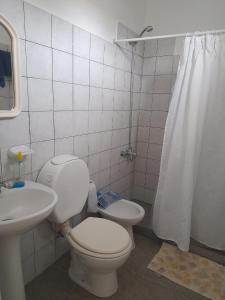 Baño blanco con aseo y lavamanos en Casa de descanso para 6 en Tandil en Tandil
