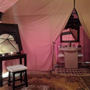 a room with a tent with a chair and a mirror at Deep Desert Camp in Merzouga
