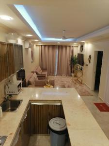 a kitchen with a counter top and a living room at Amwaj hotel Salalah Mirbat in Salalah