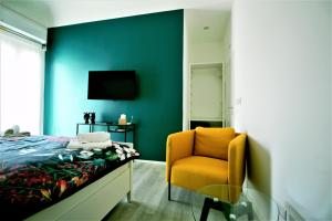 1 dormitorio con 1 cama, 1 silla y TV en B&B Belvedere All'Idria, en Ragusa