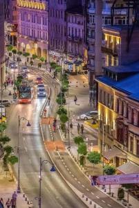 a city street at night with a bus at Brand New Downtown Studio in Bucharest