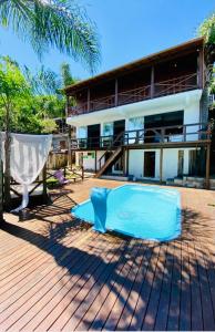 una casa con una piscina blu di fronte a una casa di Pousada Altos do Rei a Praia do Rosa