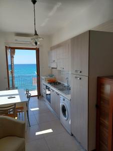 a kitchen with a washer and dryer and a table at Casa Vacanze Lifra in Santa Maria di Castellabate