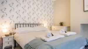 sypialnia z 2 łóżkami i ręcznikami w obiekcie The Roman Apartment w mieście Hexham