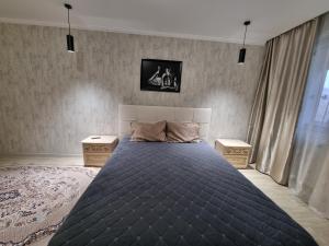 - une chambre avec un grand lit et 2 tables de chevet dans l'établissement Посуточная квартира на Кердери с Wi-Fi, à Uralsk
