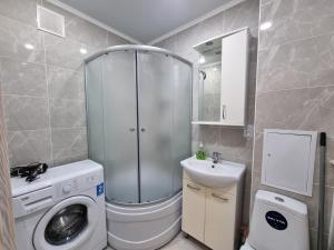 La salle de bains est pourvue d'un lave-linge et d'un lavabo. dans l'établissement Посуточная квартира на Кердери с Wi-Fi, à Uralsk