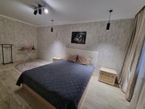 - une chambre avec un lit et une couette bleue dans l'établissement Посуточная квартира на Кердери с Wi-Fi, à Uralsk