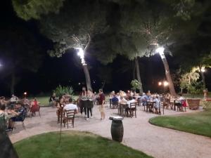 Agriturismo IL GREPPO في Abbadia di Montepulciano: مجموعة من الناس يجلسون على الطاولات في الحديقة في الليل