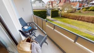 een balkon met een stoel en uitzicht op een tuin bij Appartementhaus Solaris Solaris Wohnung 06 in Grömitz