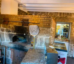 a stone kitchen with a table and a stone oven at Auberge de Thelis in Thélis-la-Combe