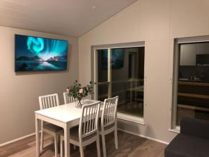 comedor con mesa blanca y sillas en EYVÍK Cottages - Private HOT TUB!, en Selfoss