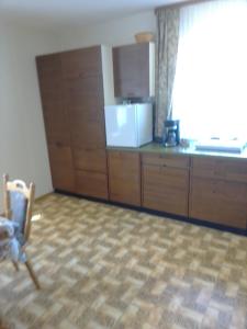 a kitchen with wooden cabinets and a chair in a room at Ferienhaus Frankenhöhe in Diebach +25 photos