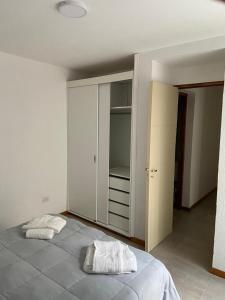 1 dormitorio con 1 cama grande y 2 toallas. en Departamento 2 habitaciones planta baja Hasta 4 huéspedes en Tunuyán