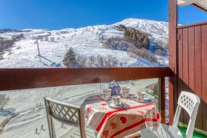 a table and chairs on a balcony with a snow covered mountain at Orion 1416 in Villarembert