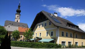 ein großes Gebäude mit einem Uhrturm im Hintergrund in der Unterkunft Taferne in Köstendorf - Ferienwohnung Monteurzimmer in Neumarkt am Wallersee