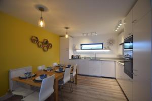 Una cocina y un comedor con mesa y sillas. en Flat 2 High Tide House - Stylish flat with large terrace and incredible sea views, en Mortehoe