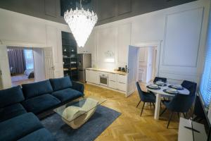キェルツェにあるPrestige Apartment Rynek Kielceのリビングルーム(青いソファ、テーブル付)