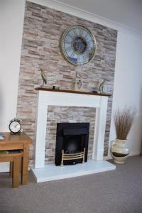 a brick fireplace with a clock on top of it at Abbey View Bagdale in the Centre of Whitby in Whitby