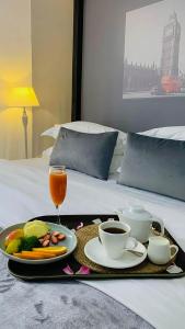 a tray of food and coffee on a bed at Bamboo Boutique Hotel in Lilongwe