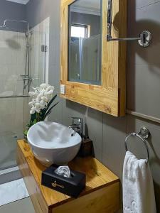 a bathroom with a bowl sink and a mirror at Bamboo Boutique Hotel in Lilongwe