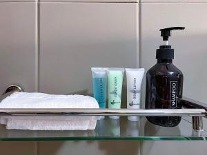 a glass shelf with towels and a bottle of soap at Bamboo Boutique Hotel in Lilongwe