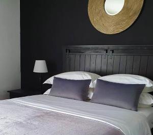 a large bed with two purple pillows on it at Bamboo Boutique Hotel in Lilongwe