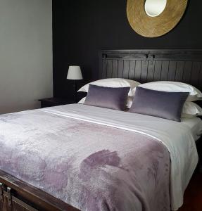 里郎威的住宿－Bamboo Boutique Hotel，一间卧室配有一张带紫色枕头的大床