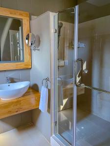 a bathroom with a glass shower and a sink at Bamboo Boutique Hotel in Lilongwe