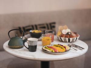 una mesa con platos de comida y bebidas. en Maisons du Monde Hôtel & Suites - Marseille Vieux Port en Marsella