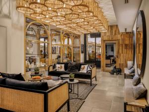 un salon avec des canapés et un lustre dans l'établissement Maisons du Monde Hôtel & Suites - Marseille Vieux Port, à Marseille