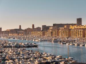 ein Hafen voller Boote in einer Stadt in der Unterkunft Maisons du Monde Hôtel & Suites - Marseille Vieux Port in Marseille