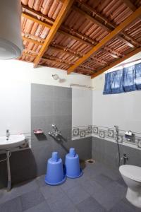 a bathroom with a toilet and a sink at Sardar Bahadur's Heritage Bungalow Estate Stay in Napoklu