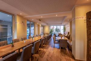 a long table and chairs in a room with windows at Hotel-Restaurant Weinhaus Grebel in Koblenz
