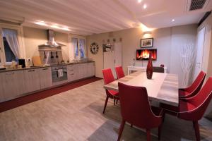 una cucina e una sala da pranzo con tavolo e sedie rosse di San Marco Fenice 3bdr 2bth apartment a Venezia