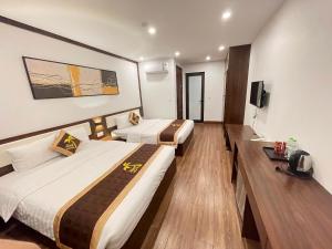 a hotel room with two beds and a television at Aland Hotel in Ha Long