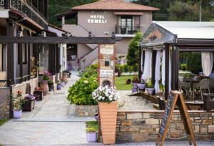 a patio with flowers and a sign in front of a building at Kamelia & Semeli Hotel in Skala Potamias