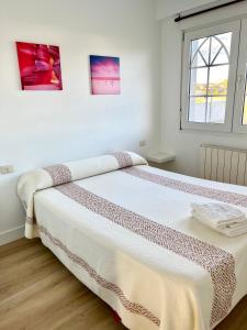 a white bedroom with a large bed in it at Pensión Maruja * in O Pedrouzo