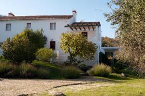 una casa blanca con árboles y un patio en Quinta da Saimeira en Marvão